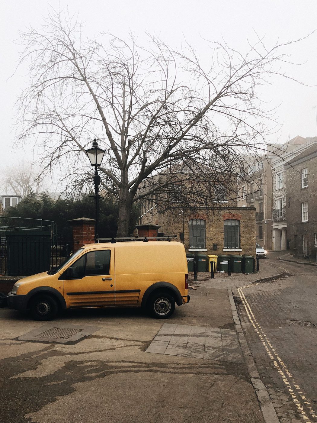 Van parked on a foggy London cobbled street